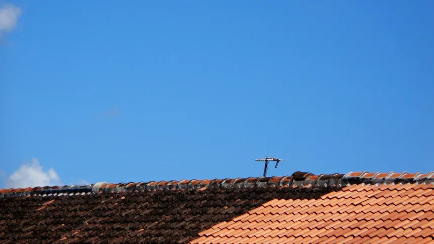 A newly tiled red roof on a Harold Hill home set against a blue sky