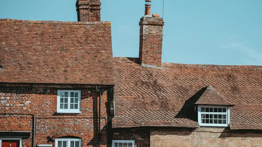 A roofscape of period Romford homes with pitched tiled roofs and chimney stacks