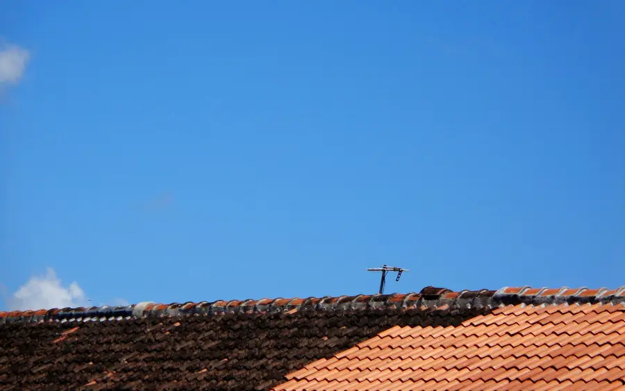 After: a new tiled roof with fresh fascias against a blue sky