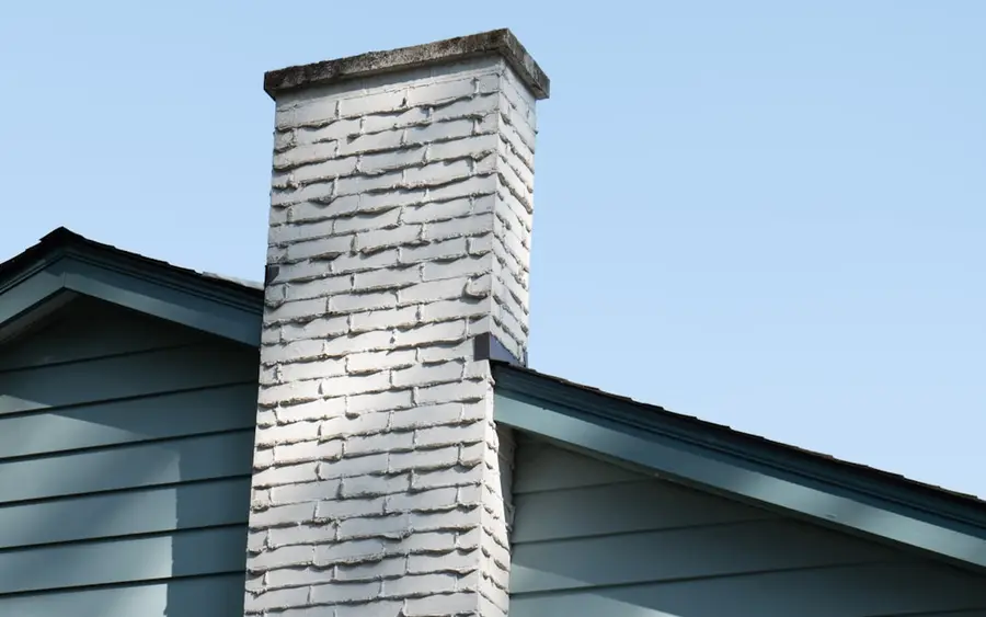 Before: a spalled, weathered chimney stack in poor condition