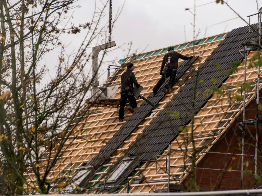 Ridgeline roofers working on a steep tiled roof with scaffolding in place